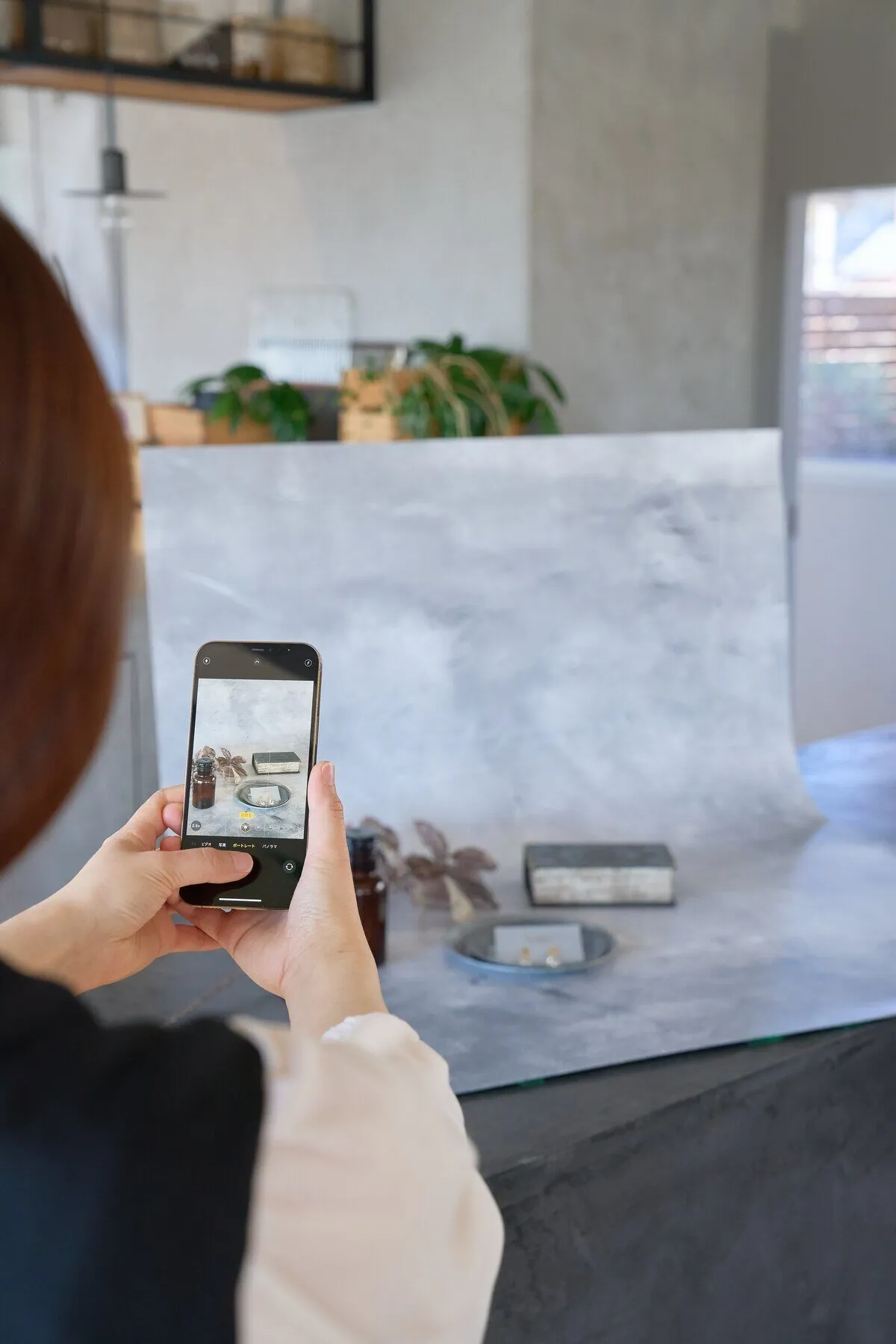 背景シートを立てて、スマートフォンで小物を撮影する様子